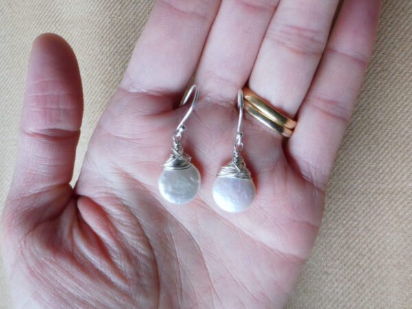 white pearls on sterling silver wire and hooks being held